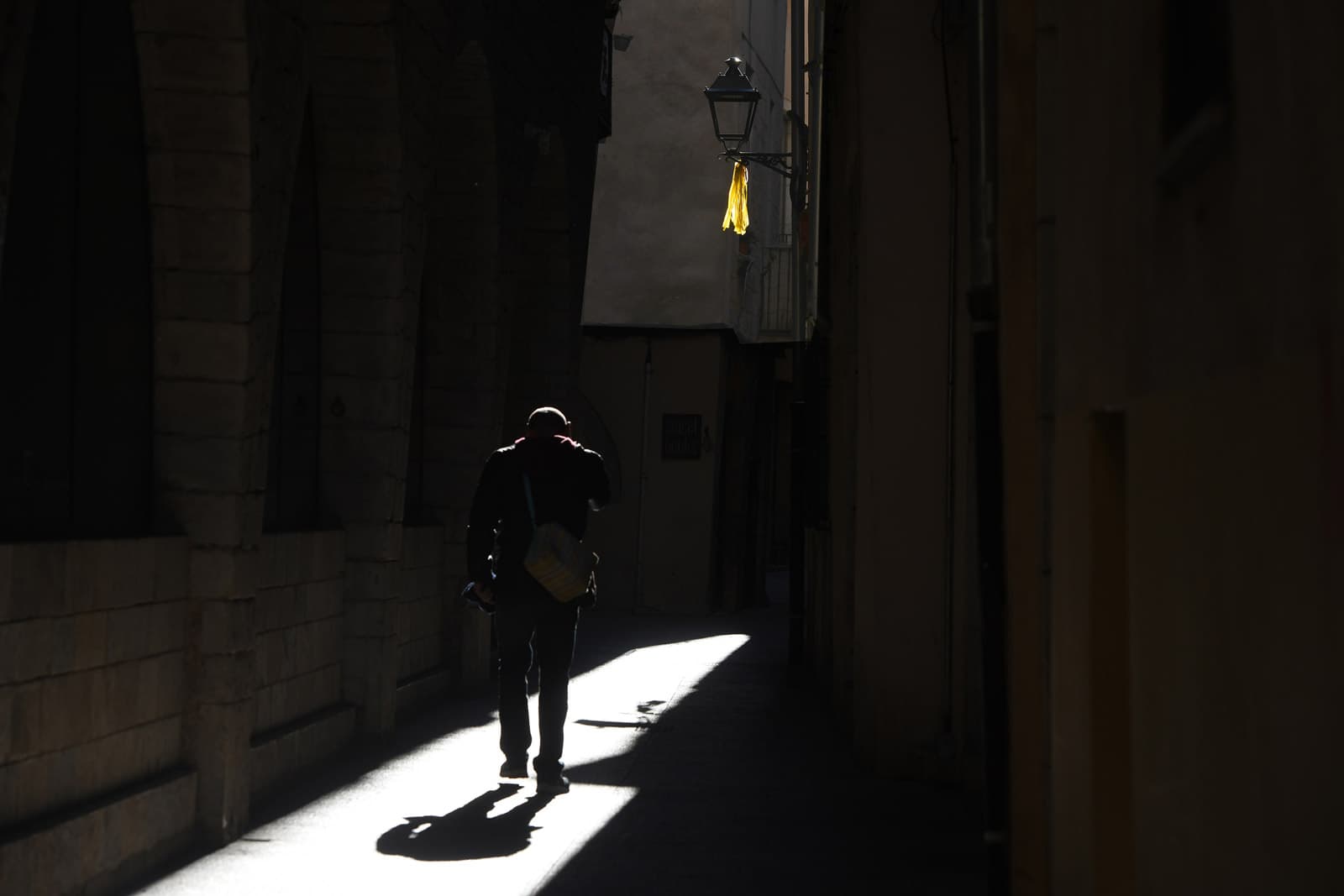 Un llaç groc en un fanal d’un carrer del barri Vell de Girona. © Xavier Jubierre