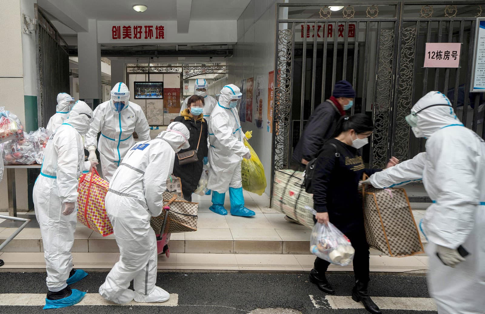 Pacients, que han complert la quarantena, surten del centre d'internament de Wuhan envoltats de grans mesures sanitàries, avui. Fotografia de Fei Maohua/Imago images