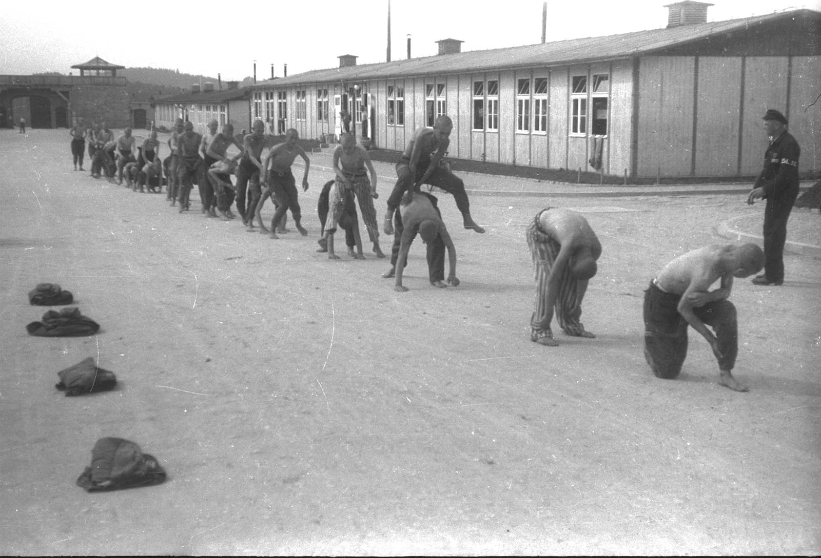 Grup de republicans supervivents a l’Appellplatz, davant de les torres d’entrada de Mauthausen. Per damunt dels seus caps oneja una bandera republicana. Maig del 1945. Fotografia de Francesc Boix. MHC. Fons Amical de Mauthausen-Francesc Boix Campo (amb el permís de la família Boix)